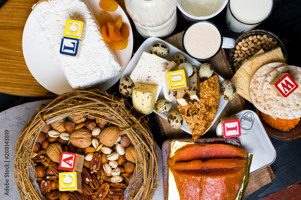 group pf products rich in calcium such as nuts, milk, peas, sardines, lentils, kidney beans, cottage cheese, yogurt, buttermilk, biscuits, dried apricots, salmon. Healthy food. Flat lay