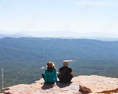 traveler young couple sitting and watching the forest scenery