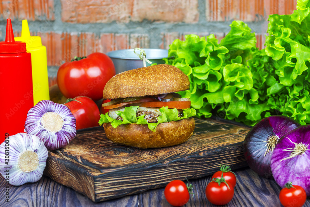 Appetizing burger on a wooden board against a background of vegetables Appetizing burger on a wooden board against a background of vegetables