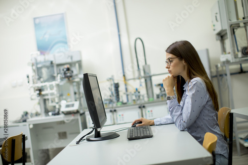Young woman sitting by the desk in the classroom