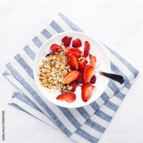 Healthy breakfast with granola, yoghurt and strawberry on the table. Top view. photo