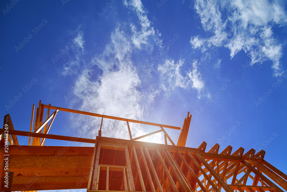 New construction home framing against blue sky,