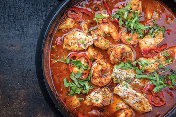 Traditional Creole cajun court bouillon with fish and seafood gumbo chowder stew as top view in a pot with copy space left