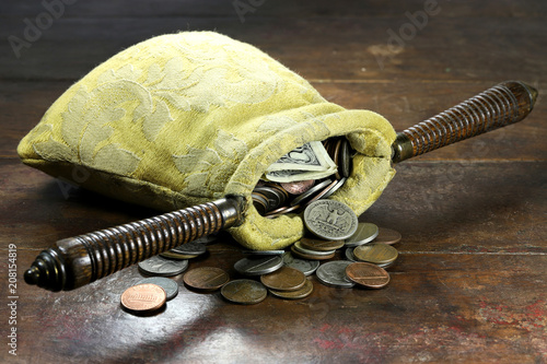 collection bag filled with US Coins on rustic wooden background photo