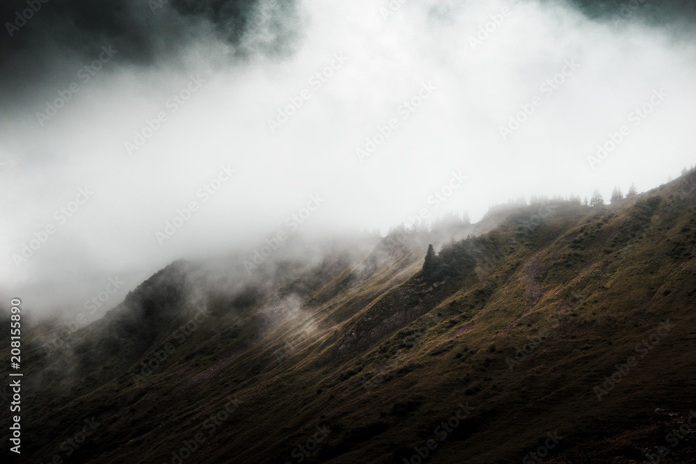 Dark ominous mountain landscape with low clouds