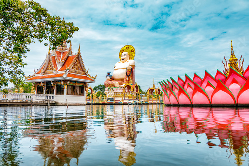 Wat Plai Laem Buddhism Temple statues during a bright sunny day with lake in the foreground in Koh Samui, Surat Thani, Thailand  photo