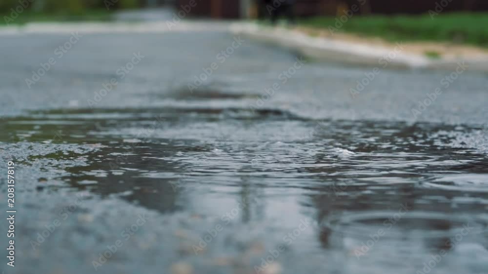 Close up slow motion shot of legs of a runner in sneakers. Female sports man jogging outdoors in a park, stepping into muddy puddle. Close up slow motion shot of legs of a runner in sneakers. Female sports man jogging outdoors in a park, stepping into muddy puddle.