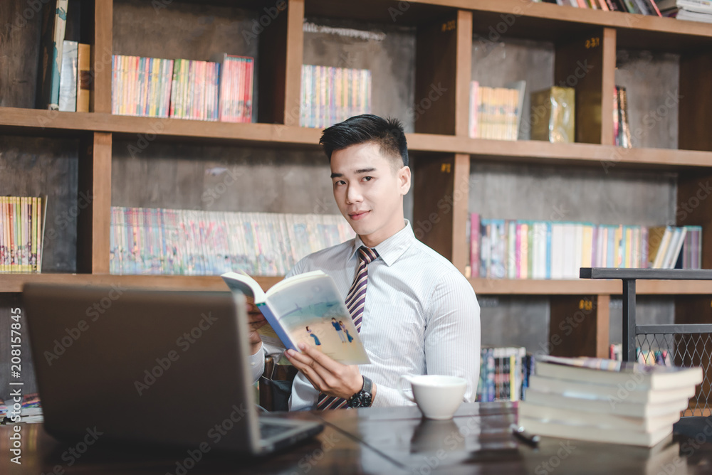 Businessman Using Laptop At Desk In Busy Office Businessman Using Laptop At Desk In Busy Office