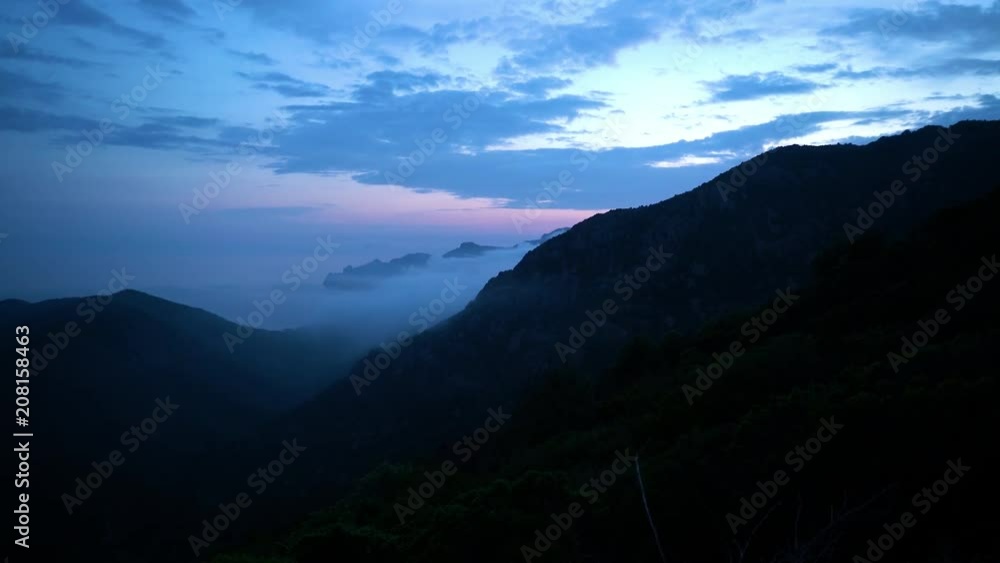 Coastline of Corsica with remote beach and covered in fog after sunset in blue hour Coastline of Corsica with remote beach and covered in fog after sunset in blue hour