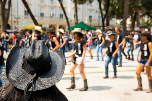 Slika na platnu Black hat on flash mob backgroung in city street