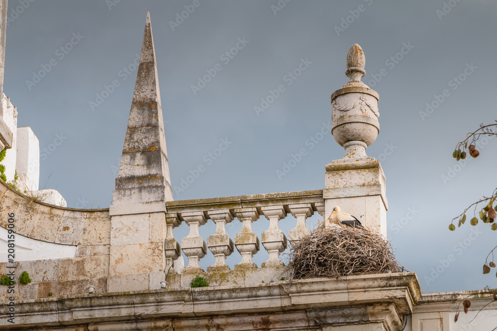 stork nest built on the arch of the city of faro