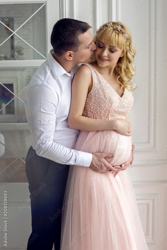 pregnant woman stands with her husband in the studio pregnant woman stands with her husband in the studio