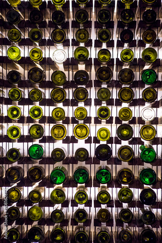 Wall of empty wine bottles. Empty wine bottles stacked-up on one another in pattern lit by the light coming from behind