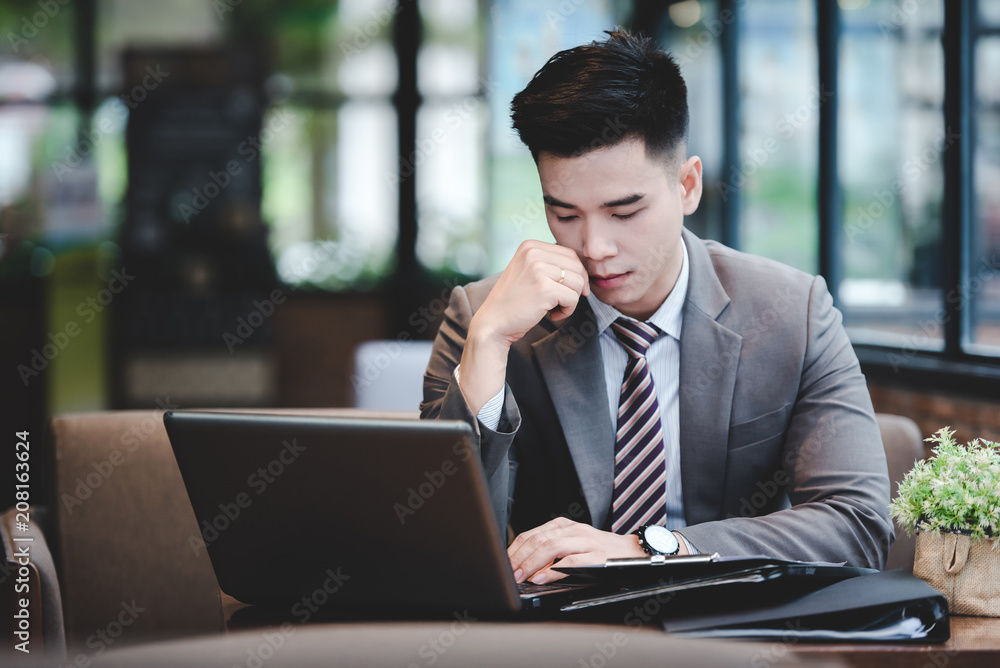 Young employee looking at computer monitor during working day in office Young employee looking at computer monitor during working day in office