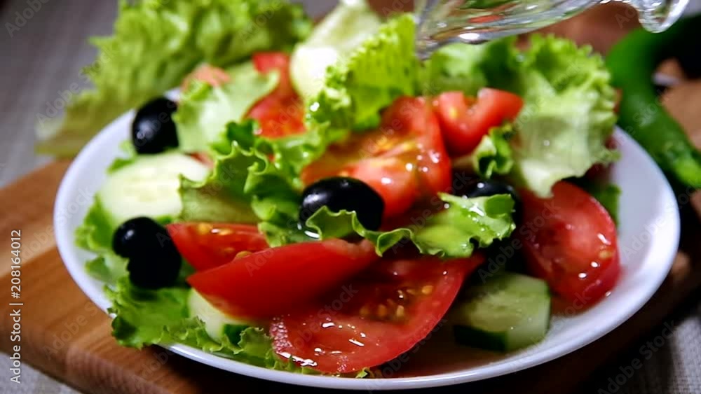 Dish with fresh salad of tomatoes, olives and cucumbers poured with olive oil Dish with fresh salad of tomatoes, olives and cucumbers poured with olive oil