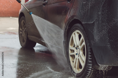Man washing a car on the car wash self-service. © Dmitriy