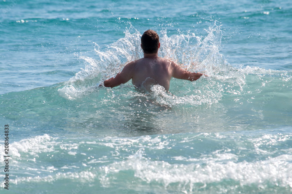 Young man in waves in the sea