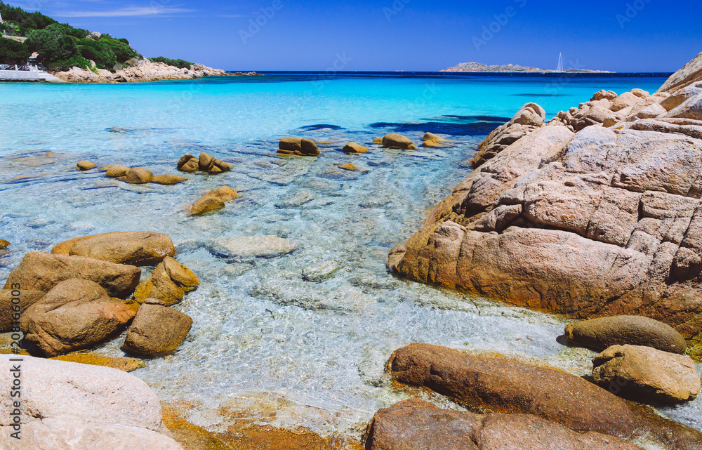 Clear amazing azure and turquoise colored sea water with huge granite rocks in Capriccioli beach, Sardinia, Italy