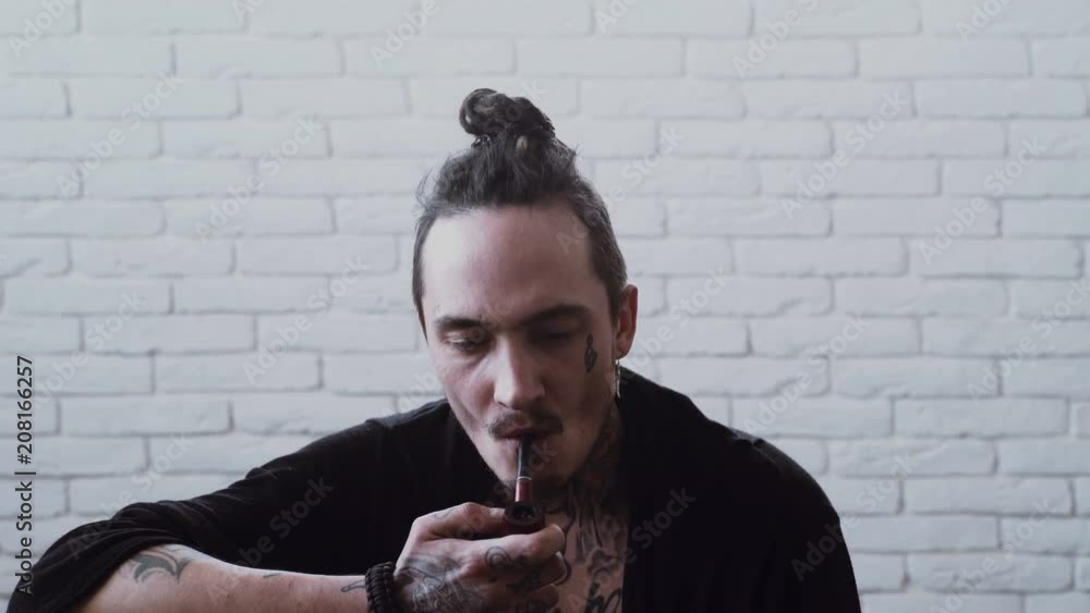 Man smoking pipe. Rasta smoker with dreadlocks. Bad habits, addiction. Unhealthy lifestyle concept Man smoking pipe. Rasta smoker with dreadlocks. Bad habits, addiction. Unhealthy lifestyle concept