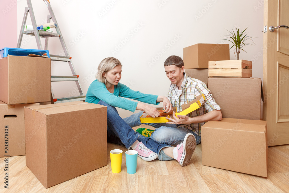 Photos of women and men eating pizza among cardboard boxes Photos of women and men eating pizza among cardboard boxes