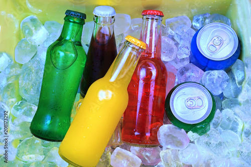 Colorful cold soda drinks, filled ice cubes in a cool box