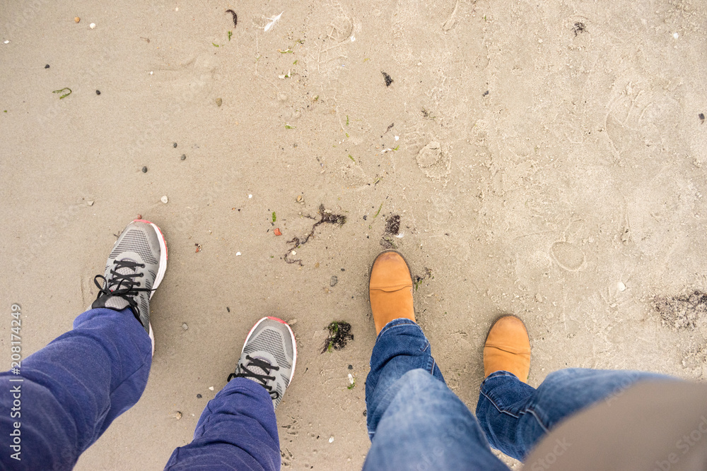 Fototapeta premium Two people legs walking on beach