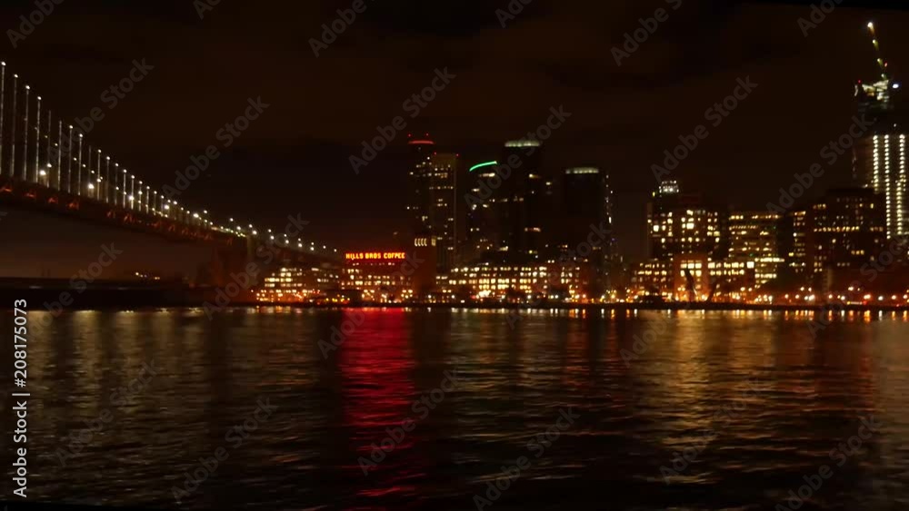 A ferry ride underneath the Bay Bridge from Oakland to San Francisco shows the city at night time. A ferry ride underneath the Bay Bridge from Oakland to San Francisco shows the city at night time.