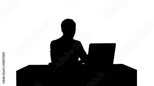 Silhouette Young businessman concentrating on working with laptop computer