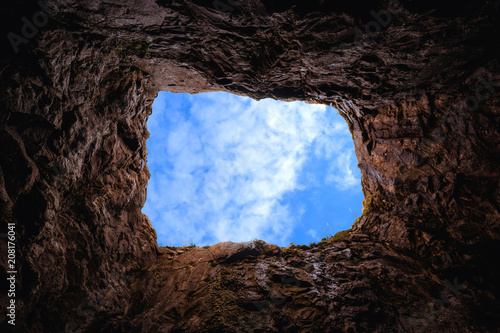 Deep rocky pit, view of the sky from the inside