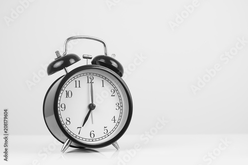 Black retro alarm clock on white background.