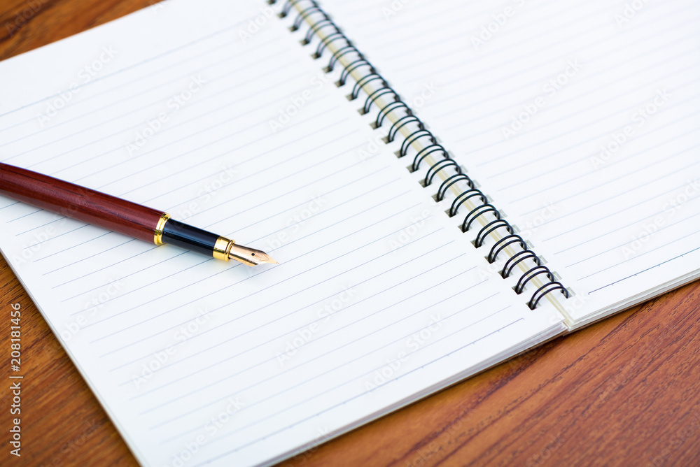 Fountain pen or ink pen with notebook paper on wooden working table with copy space, office desk concept. Fountain pen or ink pen with notebook paper on wooden working table with copy space, office desk concept.