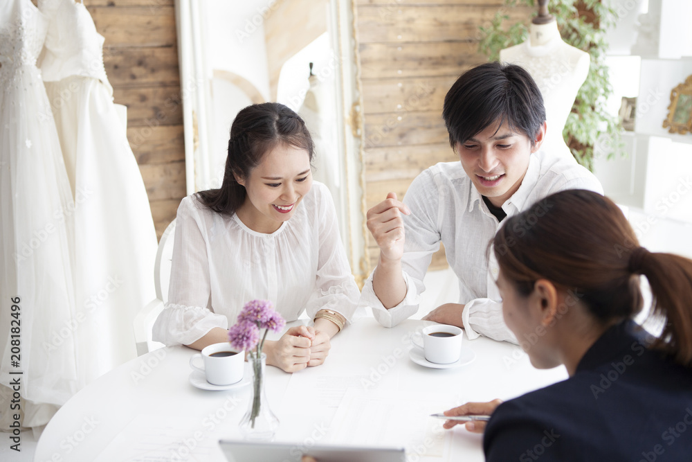 プランナーと相談をする幸せそうな夫婦 プランナーと相談をする幸せそうな夫婦