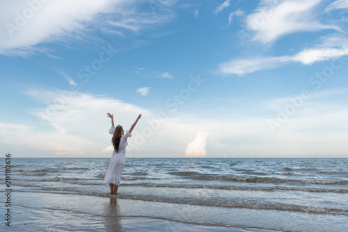Happy young woman raised hands up on the beach with happily on blue sky and sea, time to traveling concept. #208182636