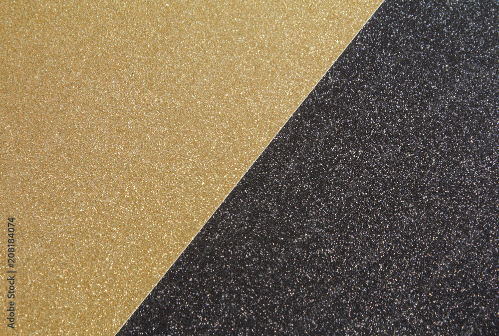 A close up of gold craft glitter paper placed against black craft glitter paper to create a black & gold textured background.