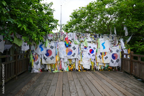 Ribbons and flags tied to the bridge of freedom left by visitors wishing peace and unification for North and South Korea - Paju, South Korea. photo