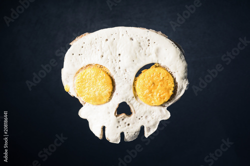 Fried eggs in the skull shape against darken background