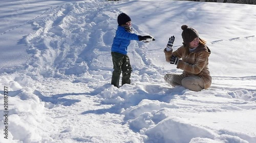Asian mother and her son playing snow together in the park , sapporo japan slow motion 