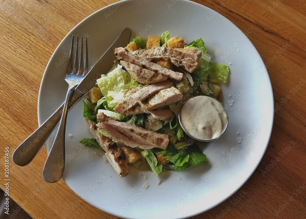 Caesar Salad Topped With Grilled Chicken Strips on White Plate; Healthy Food, Food Choices, Nutrition, Dieting, Eating Out, Classic Caesar Salad Topped With Grilled Chicken Strips on White Plate; Healthy Food, Food Choices, Nutrition, Dieting, Eating Out, Classic