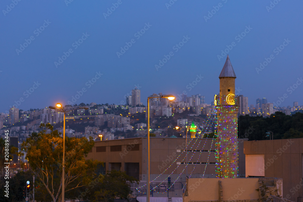 Mosque decorated for the holiday of Ramadan in Haifa Israel on the background of the night city