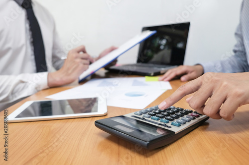 Businessman is using a calculator to calculate the numbers