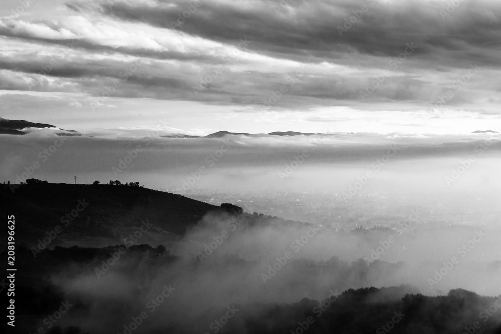 Umbria valley in autumn filled by mist, with emerging hills and 