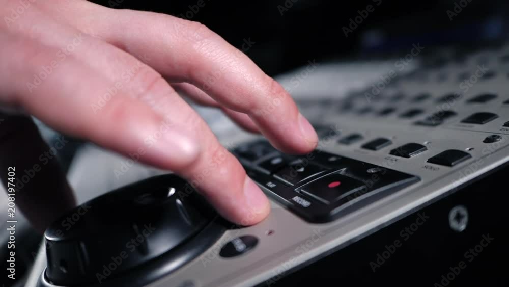 Sound engineer rotates the scroll wheel on mixing console in a professional recording studio. Musician working on new song. Slow motion. Sound engineer rotates the scroll wheel on mixing console in a professional recording studio. Musician working on new song. Slow motion.