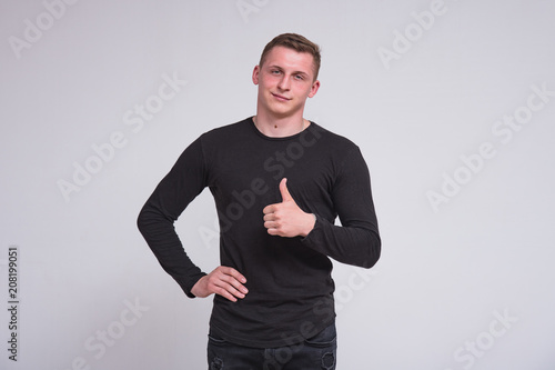 Portrait of a cute young guy showing ok on white background.