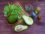 fresh avocado and avocado oil on wood background