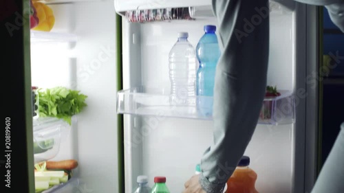 Woman taking a bottle of milk from the fridge photo