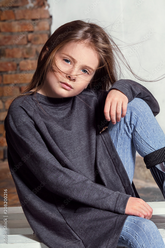 Portrait little fashion kid. Children's fashion concept. Stylish little little hipster girl looks confident, defiant. Beautiful face caucasian child. hands on her knees. Portrait little fashion kid. Children's fashion concept. Stylish little little hipster girl looks confident, defiant. Beautiful face caucasian child. hands on her knees.