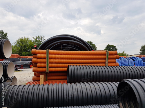 A warehouse of plastic pipes for various purposes, diameter and color under the open sky. Manufacture and sale of plastic products for construction works.om plastic. Drainage and sewerage. 