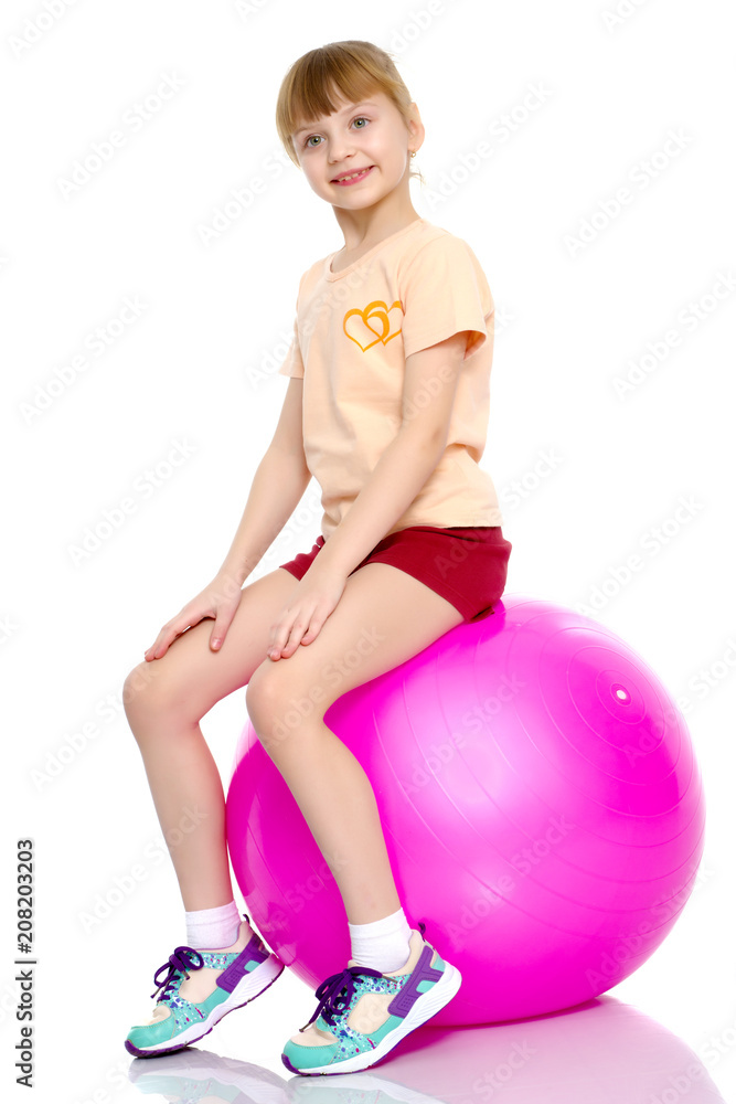 little girl doing exercises on a big ball for fitness. little girl doing exercises on a big ball for fitness.