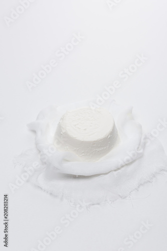 creamy cottage cheese on cheesecloth on white surface