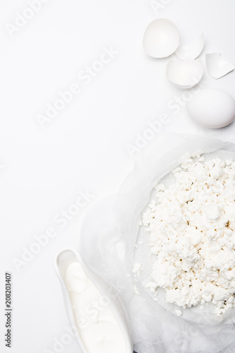 top view of cottage cheese with sour cream and eggs on white surface